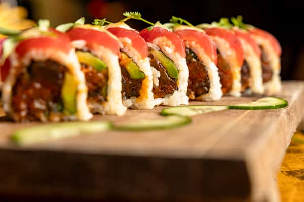 Specialty sushi roll topped with fresh tuna and signature sauces at Kapow! Noodle Bar, showcasing modern Asian fusion cuisine in Boca Raton and Delray Beach.