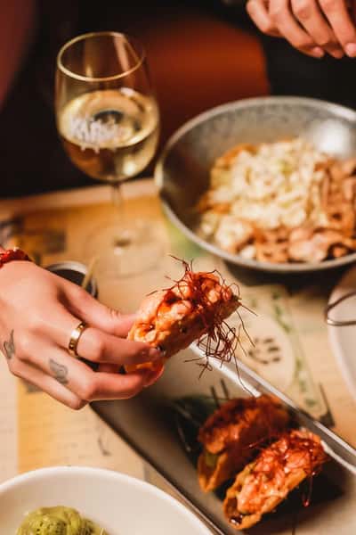 Crispy chicken wing with melted cheese pull at Kapow! Noodle Bar, showcasing bold modern Asian fusion flavors in a vibrant Boca Raton and Delray Beach dining experience.