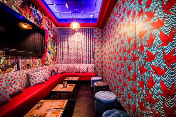 Private karaoke room at Kapow! Noodle Bar featuring bold mural artwork, plush seating, and a stylish atmosphere for celebrations, events, and late-night entertainment.