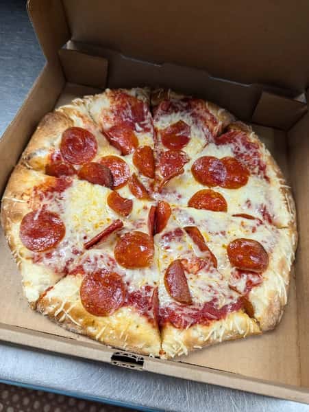 Freshly baked pepperoni pizza with melted cheese, served in an open cardboard takeout box.