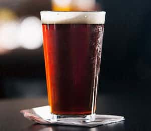dark amber beer filled pint glass