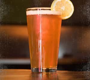 light beer filled pint glass with lemon wedge