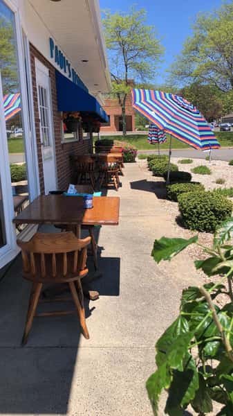 Side outside view of a few tables and chairs set up for outside dinning