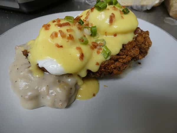 Southern-style eggs Benedict with poached eggs and hollandaise on crispy fried chicken over a biscuit with creamy sausage gravy.