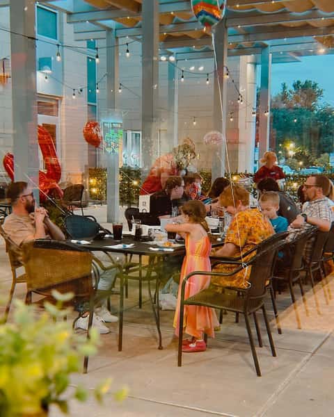 Family sitting outside restaurant on patio