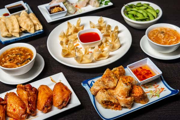 dumplings and sauce dish with chicken wings and more