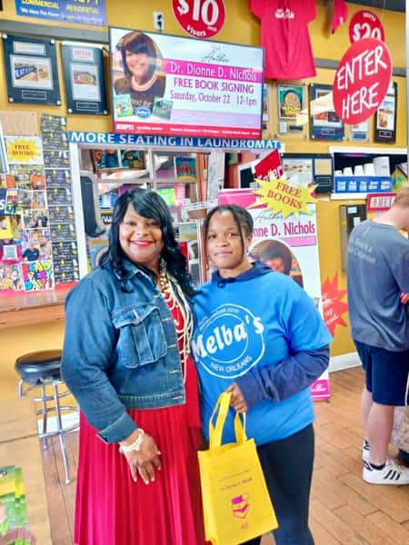 two guests smiling at Melba's New Orleans restaurant during Dr. Dionne D. Nichols book signing event with "Free Books" signage