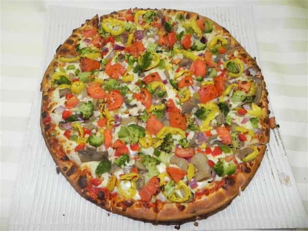 Personal vegetable pizza topped with broccoli, tomatoes, and peppers