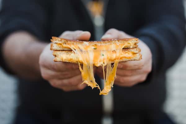 person holding grilled cheese sandwich
