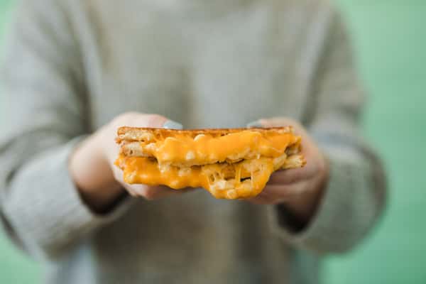 person holding grilled cheese sandwich