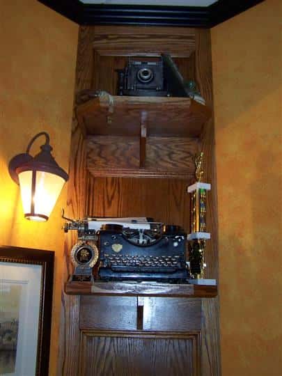 interior cabinet displaying a vintage camera and typewriter