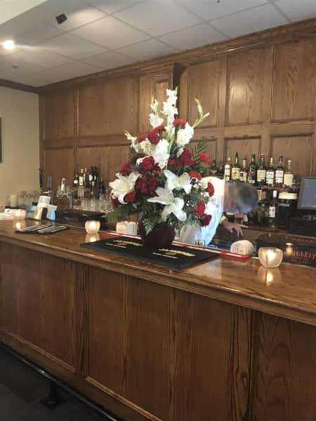 interior bar setup with liquor bottles and floral decorations