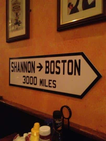 interior sign thats pointing and says shannon boston, 3000 miles away