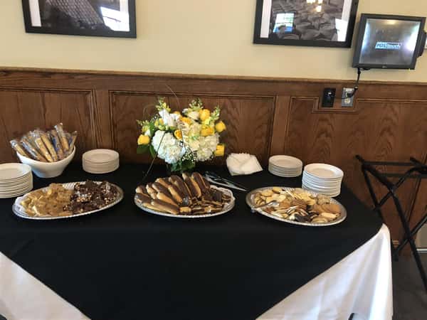 catering assortment of various desserts on a table with plates and napkins