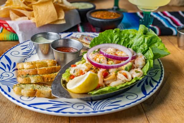 "Luscious Ceviche: Fresh medley of seafood in a lettuce bowl, enhanced with zesty lemon and served with toasted bread.