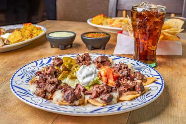 Fajita Nachos: Loaded with sizzling goodness! Grilled meat, melted cheese, and vibrant toppings on crispy tortilla chips.