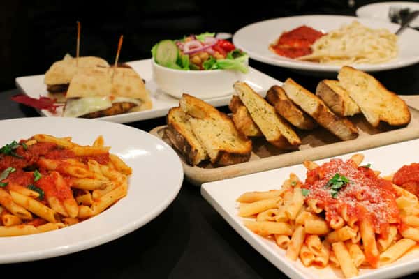 A vibrant display of Italian dishes with pasta, salad, and garlic bread in a Montreal restaurant setting.