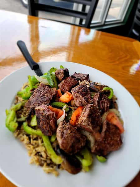 sirloin steak skillet - cut up pieces of steak with peppers and onions on a bed of rice
