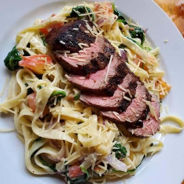 spaghetti with vegetables, cheese, and sliced meat