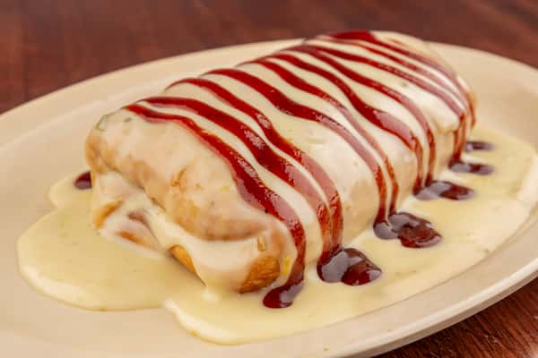 Smothered burrito topped with creamy cheese sauce and drizzled with barbecue sauce on a white plate.