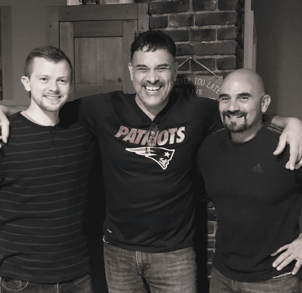 Three team members smiling together inside Hugo's restaurant, showcasing the friendly staff and welcoming hospitality behind the dining experience.