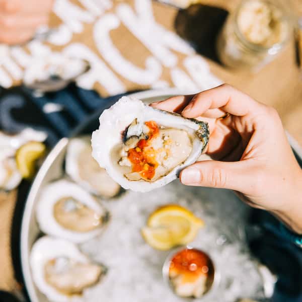 Picking up a raw oyster