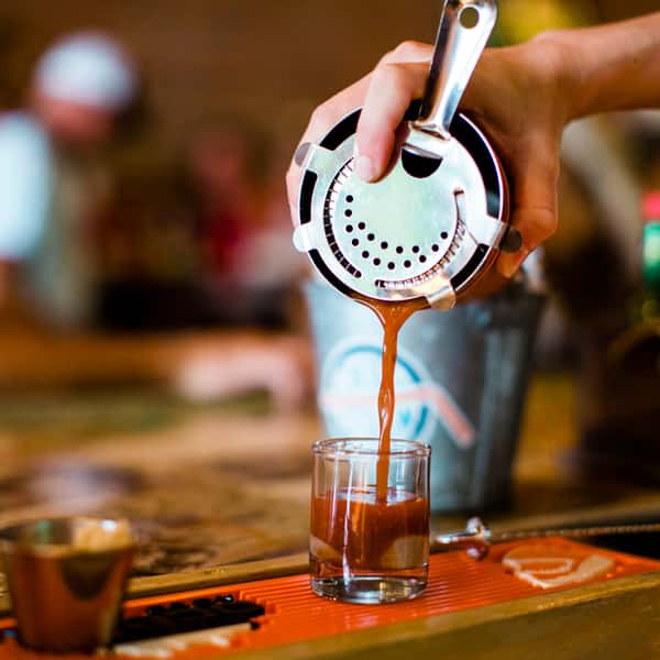 Bartender pouring a oyster shooter shot at the bar