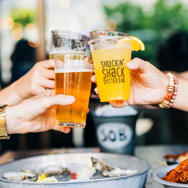 Guests toasting with drinks in Shuckin' Shack glasses