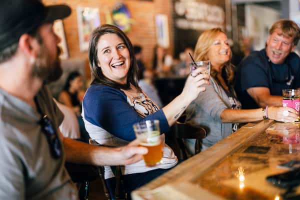Guests laughing while enjoying cold beer at the bar