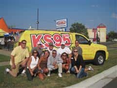People taking a group photo in fron of a van