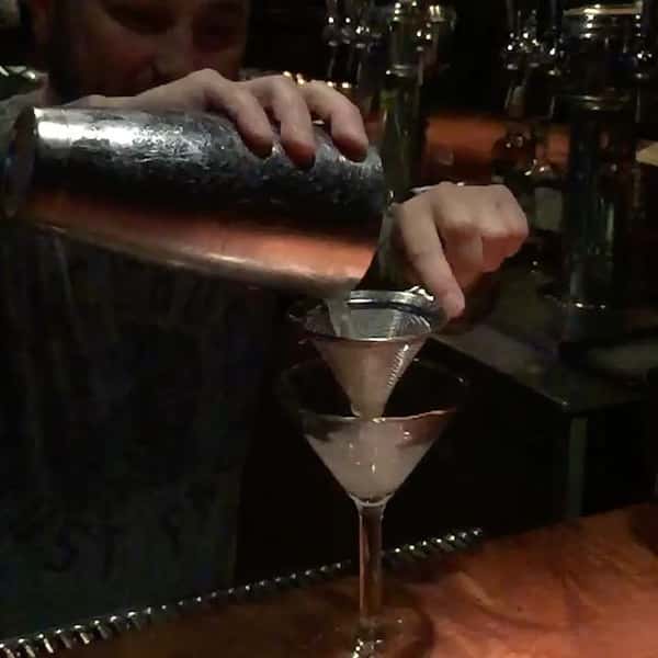 bartender straining drink