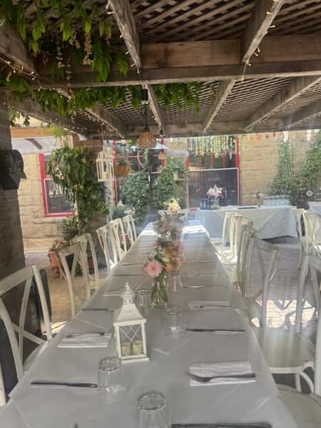 White tablecloths and beautiful setting in the trellis