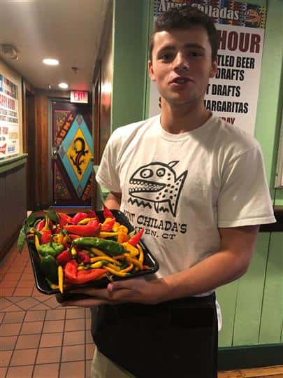a waiter holding a container full of peppers