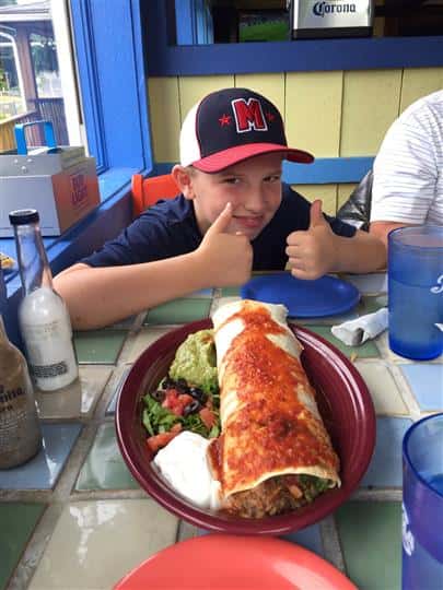 a customer putting his thumbs up next to a giant enchilada