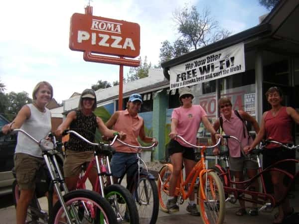 kids on bikes roma pizza sign at the back