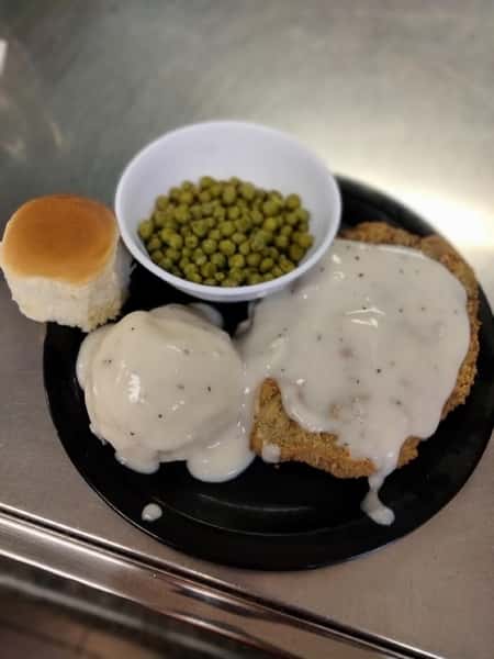 chicken, mashed potatoes with gravy, peas, and roll
