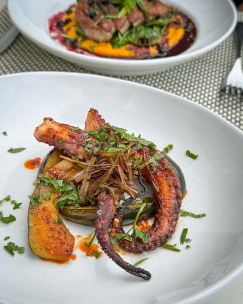 Seared Octopus at Town Hall, with spiced squash, crispy leeks + Calabrian chili crunch.