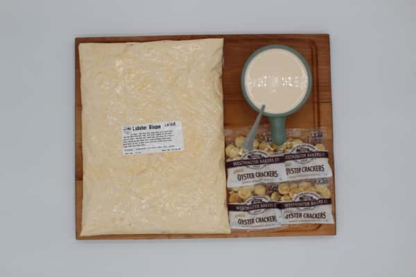 Lobster bisque with chowder crackers in a bag and cup on display board