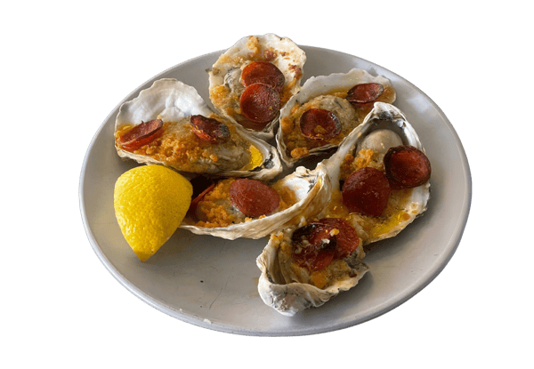 Oysters Casino on white plate with lemon