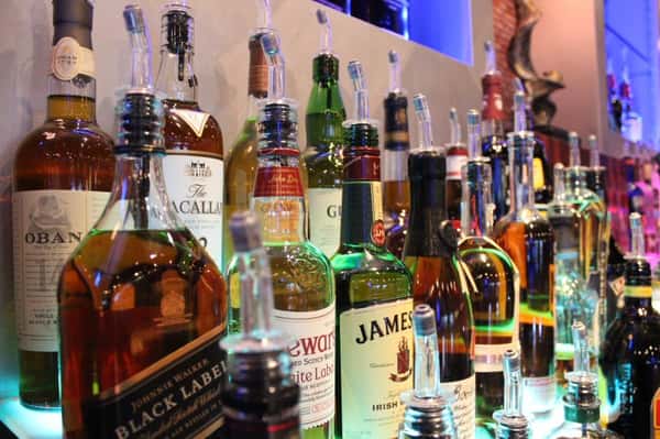 Assortment of liquor bottles stacked behind bar