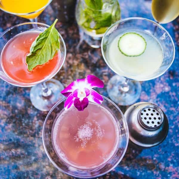 Assorted cocktails with floral garnishes