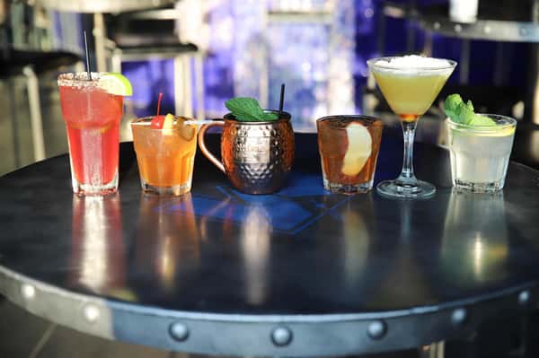 Assortment of cocktails lined up along bar