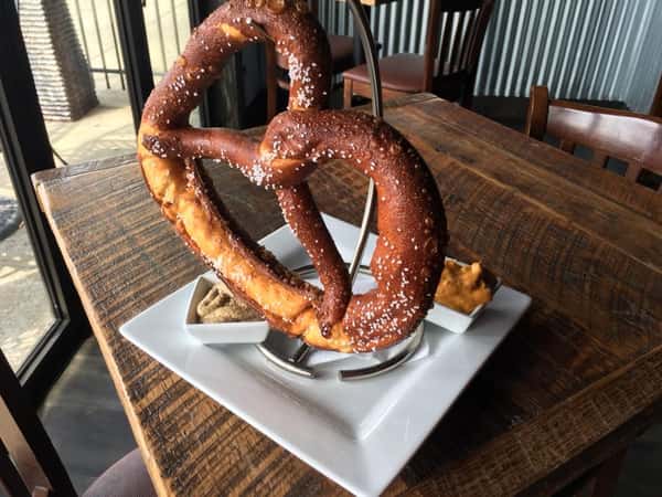 Crispy baked pretzel hanging from metal stand