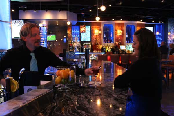 Bartender serving drink to person