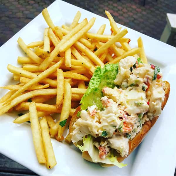 lobster roll on a toasted bun with a side of french fries