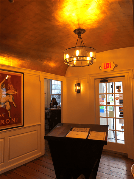 view of the host stand under a light fixture on the wall