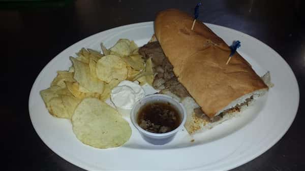 Steak Sandwich with a side of chips and sauce