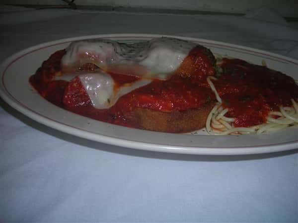 Spaghetti and meatballs with cheese topped on bread
