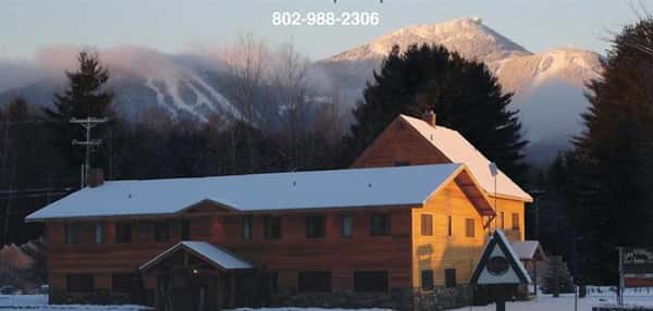 exterior building to the jay village inn during the winter, covered in snow