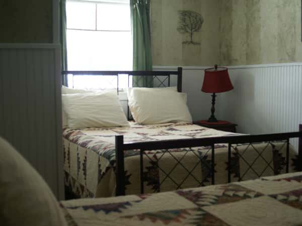 suite with a large bed next to a night stand with a lamp